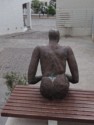 Sculpture of a man sitting on a bench